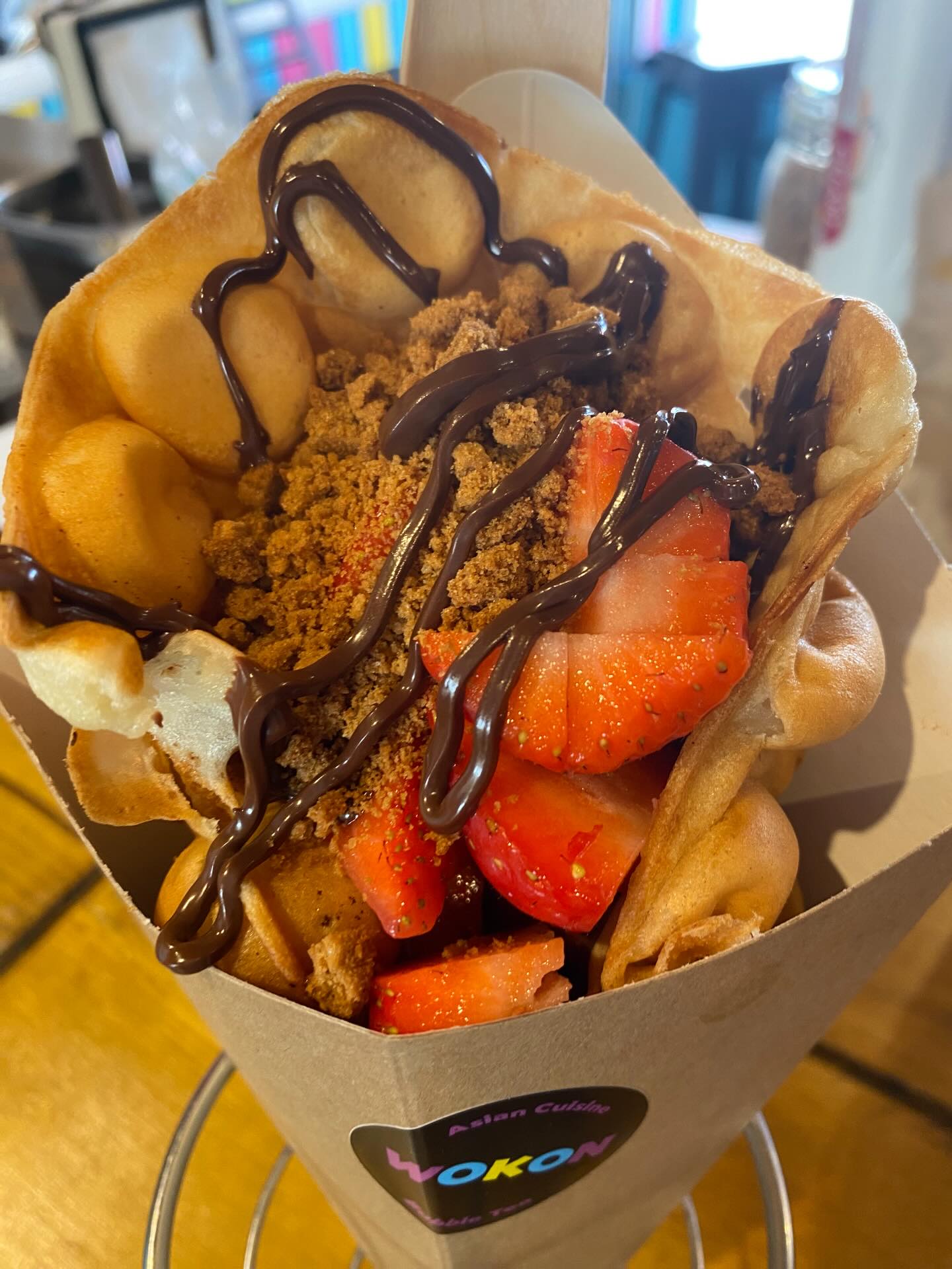 Bubble waffle cone with strawberries, Biscoff crumb and chocolate